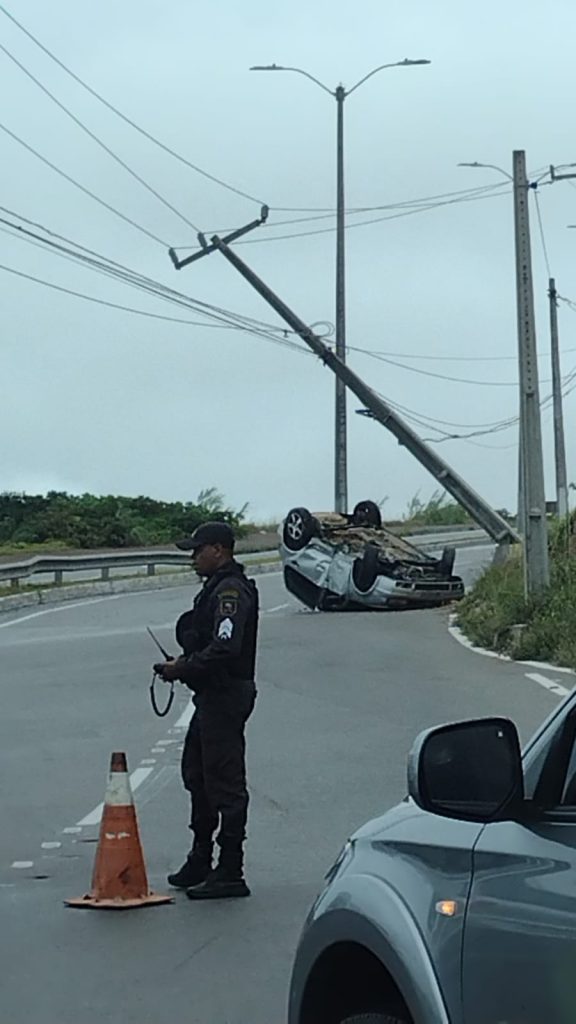 Carro capota, derruba poste e interditada trecho da Via Costeira