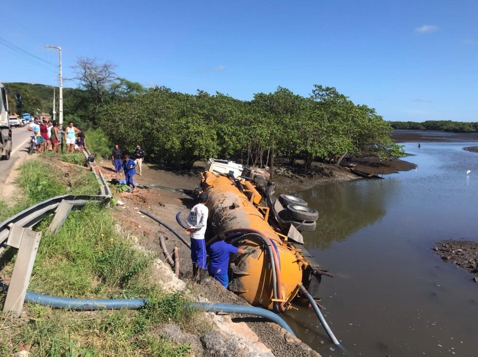 Um caminhão de uma empresa limpa-fossas tombou e caiu no rio Guarapes, em Natal, na manhã desta segunda-feira (25).